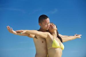 glückliches junges Paar, das den Sommer am Strand genießt foto