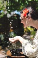 frisches Wasser auf die Hände der Frau spritzen foto