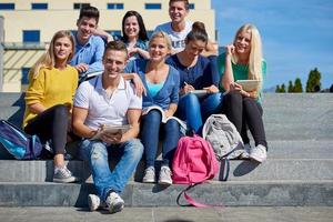 Studenten sitzen draußen auf Stufen foto