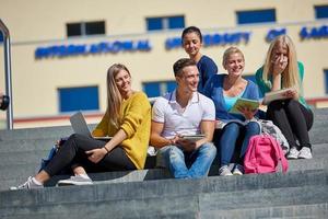 Studenten sitzen draußen auf Stufen foto