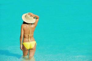 hübsche Frau, die sich am tropischen Strand ausruht foto