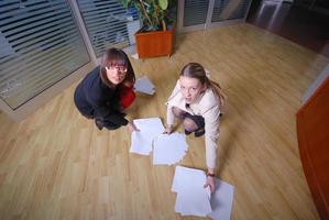 zwei Geschäftsfrauen werfen Papiere im Büro foto