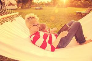 Mama und eine kleine Tochter, die sich in einer Hängematte entspannen foto