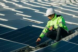 Das Porträt eines jungen Ingenieurs überprüft Photovoltaik-Solarmodule. Konzept. Erneuerbare Energietechnologie Stromdienst, Ökostrom. foto