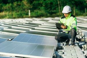 Das Porträt eines jungen Ingenieurs überprüft Photovoltaik-Solarmodule. Konzept. Erneuerbare Energietechnologie Stromdienst, Ökostrom. foto