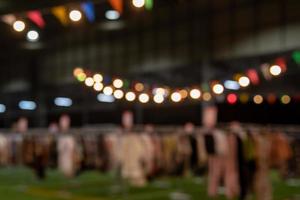 Verschwommenes Bild von Nachtmarktfestival-Menschen, die auf der Straße mit hellem Bokeh für den Hintergrund gehen. foto