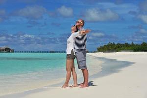 glückliches junges Paar in den Sommerferien hat Spaß und entspannt sich am Strand foto