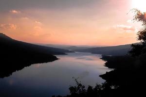 schöne naturlandschaft berg- und flussblick himmel bei sonnenuntergang foto