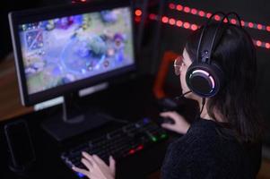 junge professionelle Streamerin und Gamerin mit Headset, die Online-Videospiele spielt foto