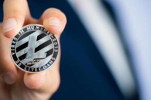 litecoin ltc enthalten mit kryptowährung auf hand geschäftsmann, der einen blauen anzug trägt. abgelegt und abgelegt und mir gegeben. foto