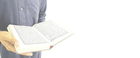 mann, der koran hält und liest. islamischer Hintergrund foto