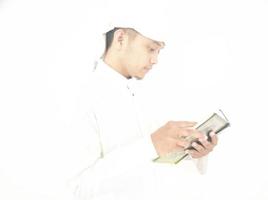 mann, der koran hält und liest. islamischer Hintergrund foto