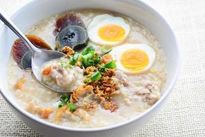 Congee, Reisbrei mit gehacktem Schweinefleisch, gekochtem Ei und Jahrhundertei, ideal zum Frühstück. foto