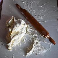 hölzernes Nudelholz mit weißem Weizenmehl auf dem Tisch foto