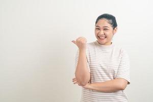 asiatische frau mit der hand, die auf wand zeigt foto