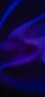 Falsches Violett-Blau der Wüstenansicht aus Stofffalten mit dunklem Hintergrund. foto