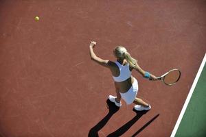 junge Frau spielt Tennis im Freien foto