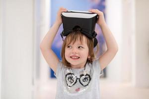 kleines Mädchen zu Hause mit VR-Brille foto