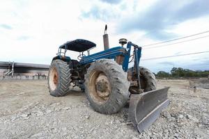 Traktor blau geparkt auf einer Lichtung in Vorbereitung auf Mutterboden und schönen blauen Himmel im Hintergrund. Das Konzept eines Bulldozers bereitet den Oberboden für den Bau vor. foto