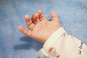 neugeborene Babyhand. Nahaufnahme des Neugeborenen mit der Hand auf weißem Hintergrund mit Kopierraum, Panoramabanner des Kindertagesstättenkonzepts foto