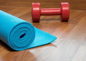 blaue Yogamatte und rote Hantel foto