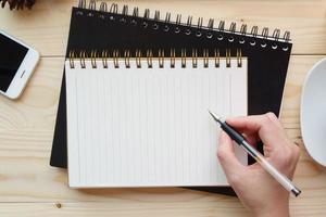 hand schreiben notizbuch auf holz schreibtischarbeit