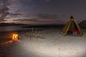 Zeltlager am einsamen Sandstrand in Kalifornien bei Nacht foto