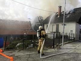 Feuerwehrmann, der einen Brand im Haus bekämpft foto