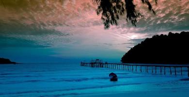 Schöner tropischer Strand, Meereslandschaft im Sonnenuntergang mit einem kleinen Boot gegen blauen Himmel und bewölktem Himmel für Reisen in der Urlaubszeit als Sommer foto