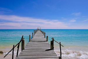 Ein hölzerner Pier, der sich bis zum Meer erstreckt, Blick auf das Meer mit bewölktem und blauem Himmel für Reisen in der Urlaubszeit als Sommer foto