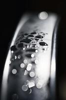 Wassertropfen abstrakt und mit verschwommenem Hintergrund glänzen auf einer Metalloberfläche eines Stuhls foto
