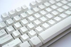 Gebrauchte weiße Computertastatur, die nicht verwendet wird, bis sie staubig wird foto