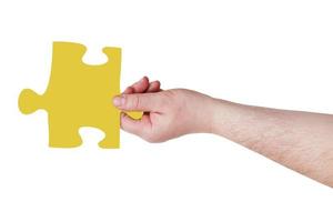 männliche Hand mit gelbem Puzzleteil foto