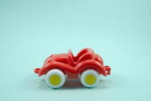 Retro-Auto mit offenem Dach Plastikspielzeug rote Farbe isoliert auf Türkis foto