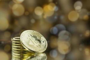 Stapel von Gold-Bitcoin-Münzen mit goldenem Bokeh-Hintergrund. foto