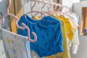 Trocknen von Babykleidung durch Aufhängen vor dem Haus. foto