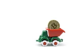 grüner Kunststoff-Spielzeug-Muldenlastwagen mit Bitcoin-Goldmünzen foto