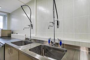 Ellbogenseife und antiseptischer Spender oder Desinfektionsmittel an der Wand montiert zur Händedesinfektion und Wasserhahn Waschbecken mit Wasserhahn Badezimmer oder Klinik foto