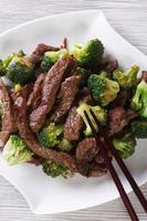 asiatisches Rindfleisch mit Brokkoli und Stäbchen. vertikale Draufsicht