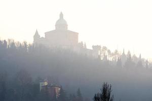 bologna, italien-januar 23,2016-blick auf das heiligtum von san luca, das an einem wintertag in nebel gehüllt ist foto