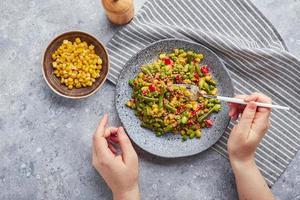 Quinoa-Salat mit grünen Bohnen, Mais, roter Paprika, Erbsen und Sojabohnen. nützliche Gemüsemischung