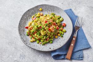 Quinoa-Salat mit grünen Bohnen, Mais, roter Paprika, Erbsen und Sojabohnen. nützliche Gemüsemischung