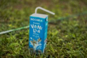 Defokussierter abstrakter Hintergrund der Blu-Box-Milch im Gras foto