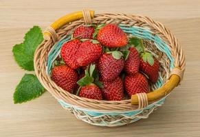 frische Erdbeere in einem Korb auf Holzhintergrund foto