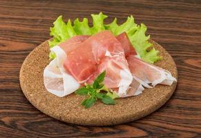 Prosciutto auf Holzbrett und Holzhintergrund foto