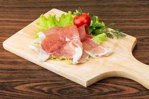 Prosciutto auf Holzbrett und Holzhintergrund foto