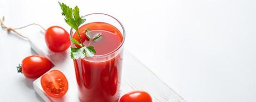 erfrischender Tomatensaft mit Kräutern auf weißem Hintergrund. veganer Gemüsedrink.