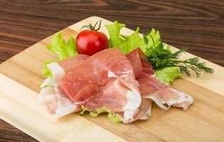 Prosciutto auf Holzbrett und Holzhintergrund foto