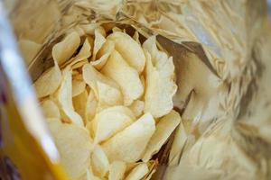 Kartoffelchips in offener Snacktüte aus nächster Nähe foto