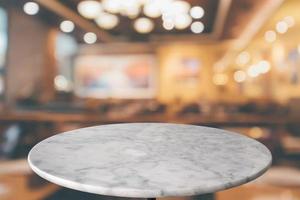 runde marmortischplatte mit bokeh-lichtern im café-restaurant abstrakter hintergrund für die montage-produktanzeige foto